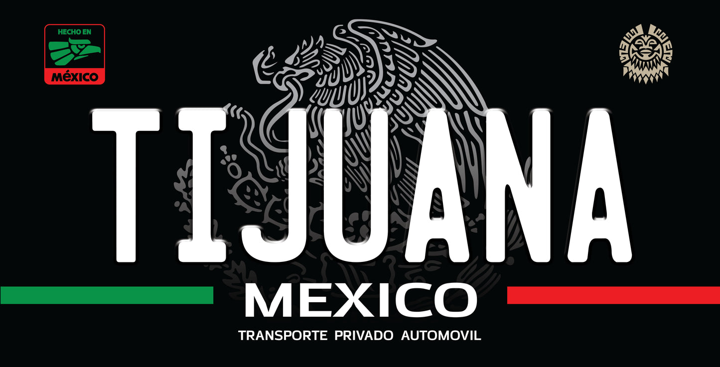 A black rectangular sign or sticker with the word 'TIJUANA' in large white letters, the Mexican eagle emblem behind it, 'MEXICO' and 'TRANSPORTE PRIVADO AUTOMOVIL' in white text, green and red horizontal bars at the bottom, and small official-style logos in the top corners.